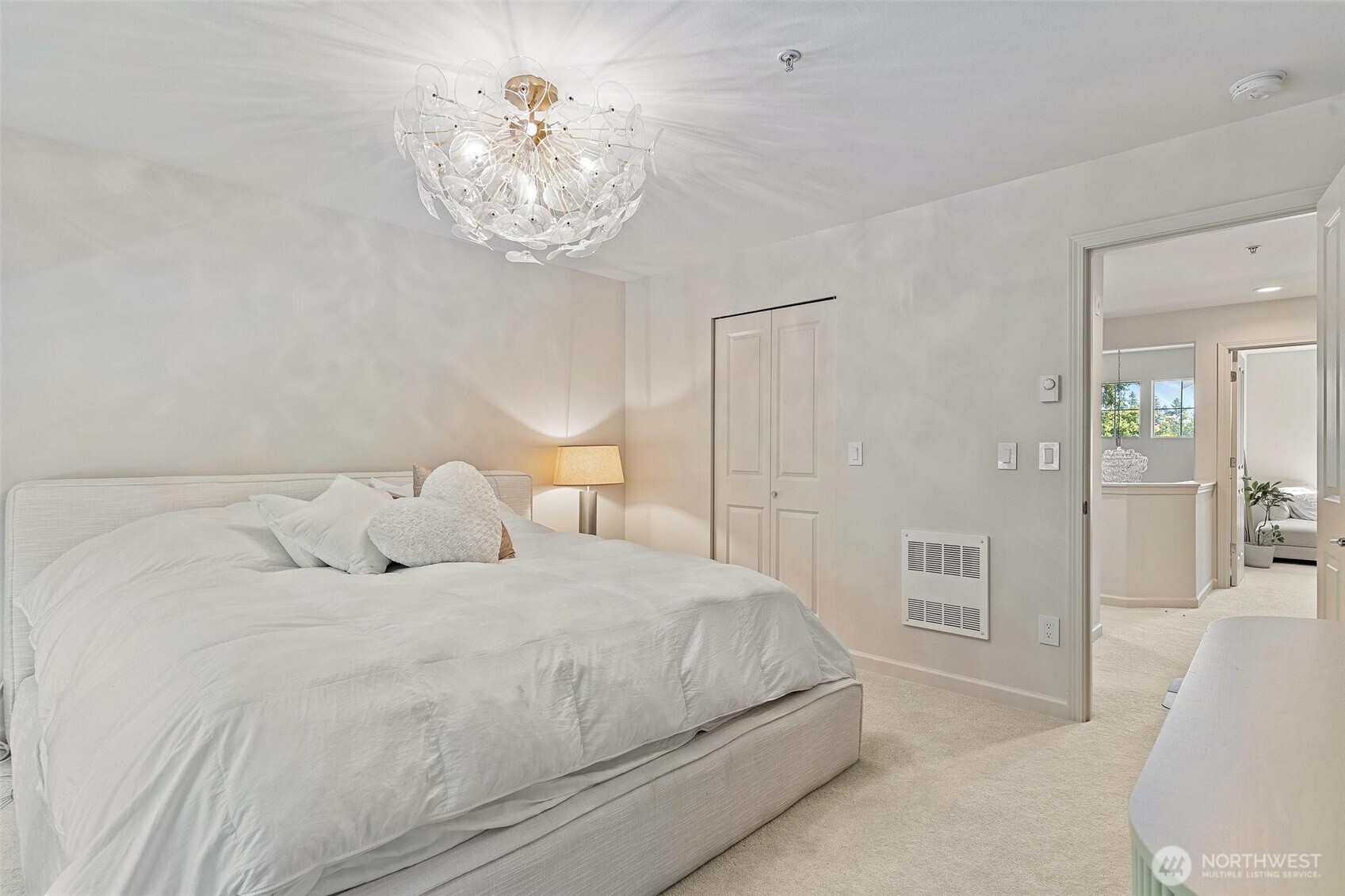 8502 Main Street, Unit E105 Edmonds, WA 98026 - Photo 21 of 39 a bedroom with a large bed and a chandelier