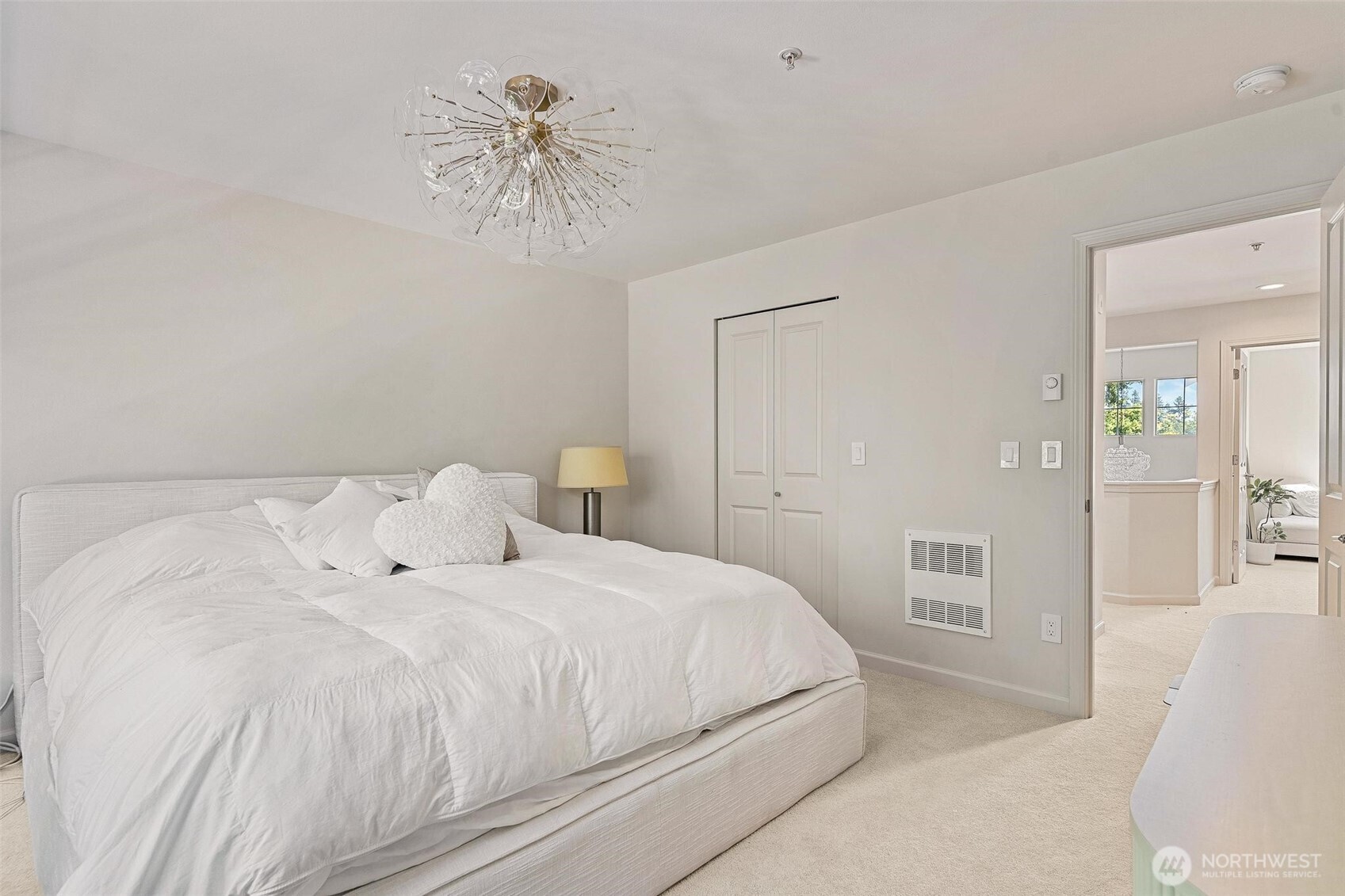 8502 Main Street, Unit E105 Edmonds, WA 98026 - Photo 24 of 39 a bedroom with a bed and a chandelier