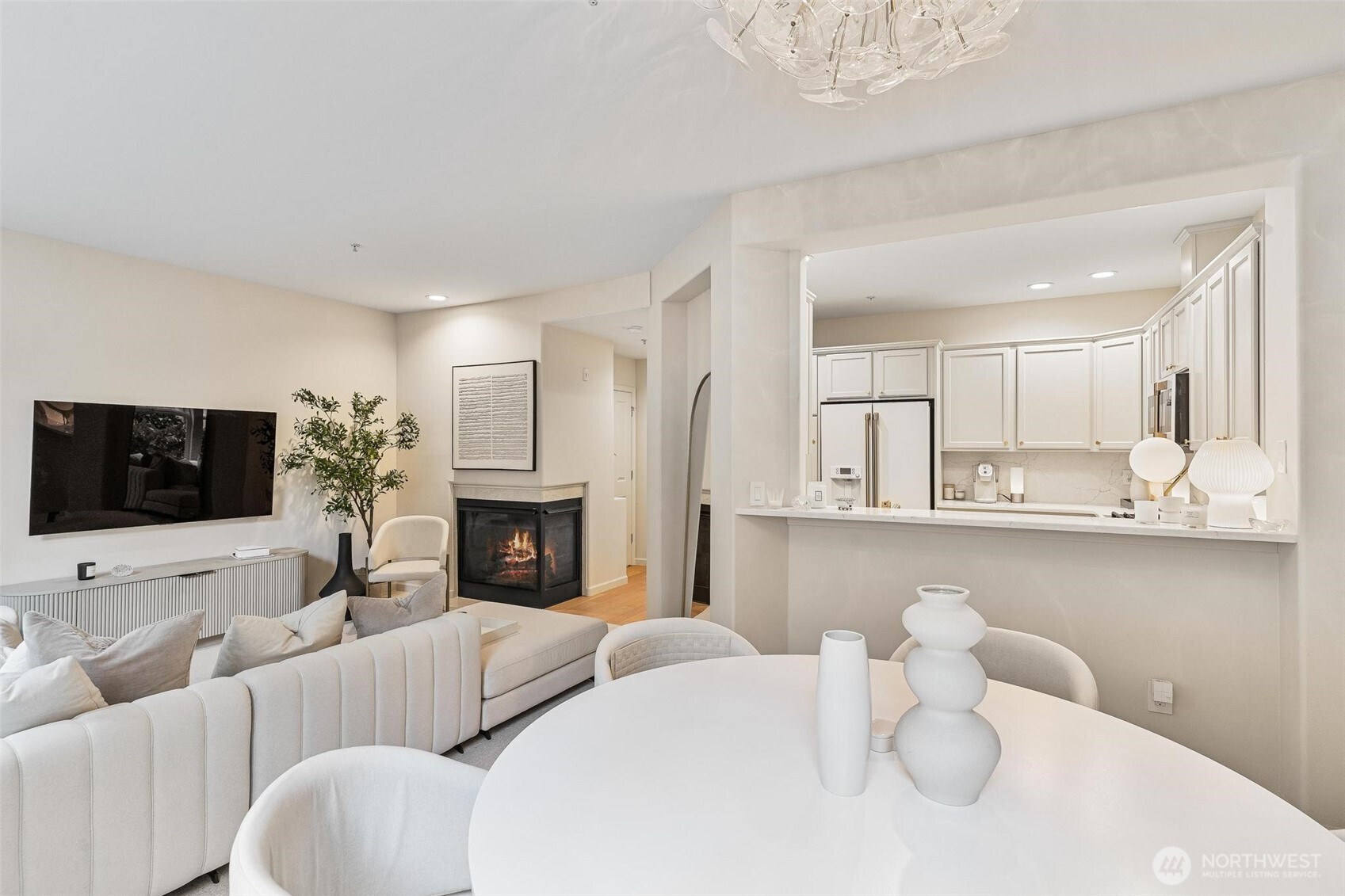 8502 Main Street, Unit E105 Edmonds, WA 98026 - Photo 3 of 39 a living room with furniture a fireplace and a flat screen tv