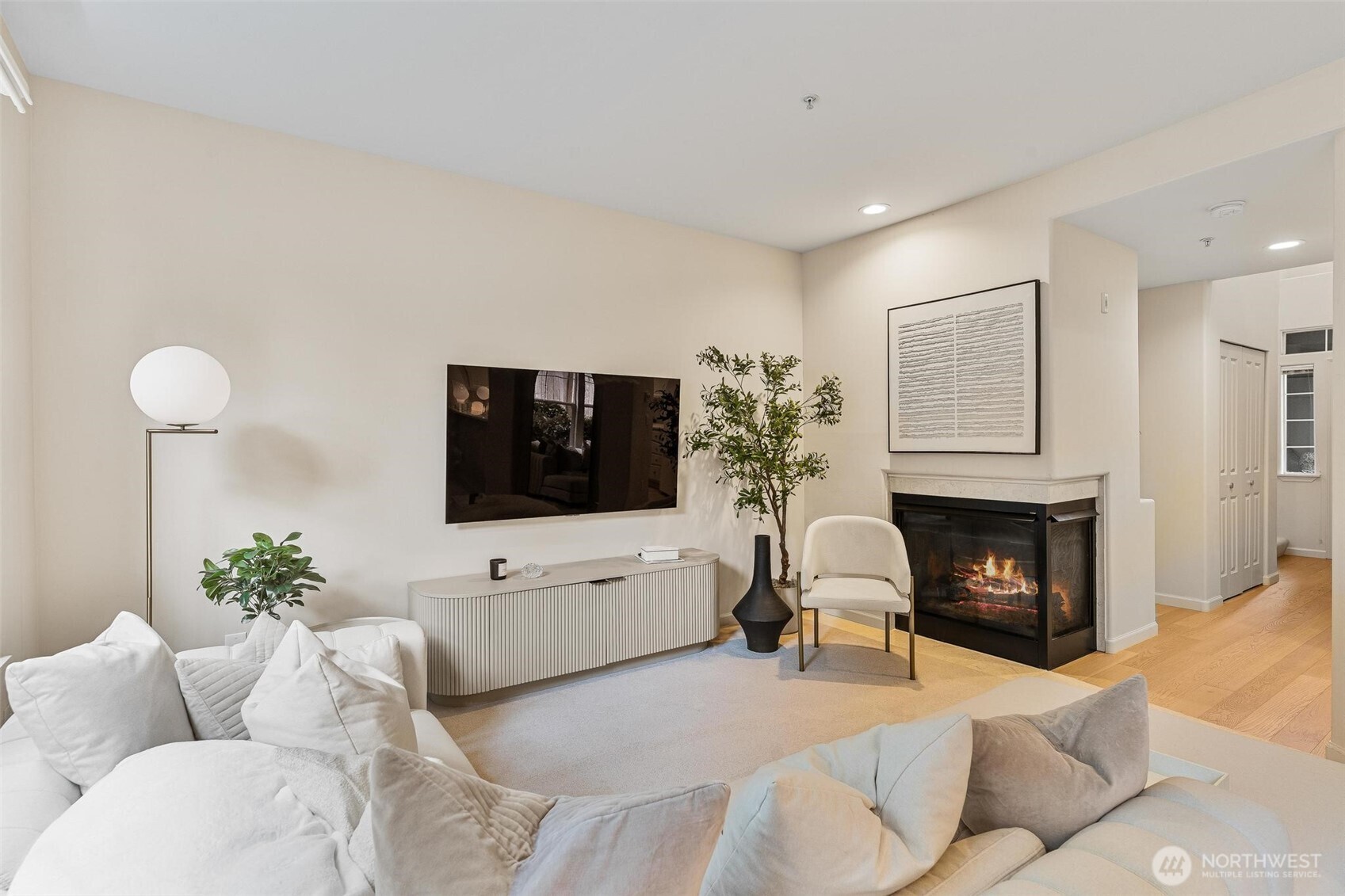 8502 Main Street, Unit E105 Edmonds, WA 98026 - Photo 4 of 39 a living room with furniture a fireplace and a flat screen tv