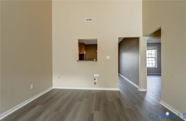 an empty room with wooden floor and mirror