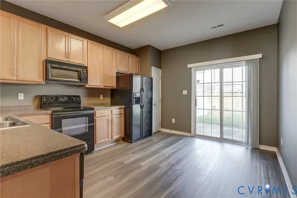 a kitchen with a refrigerator wooden floor and a sink