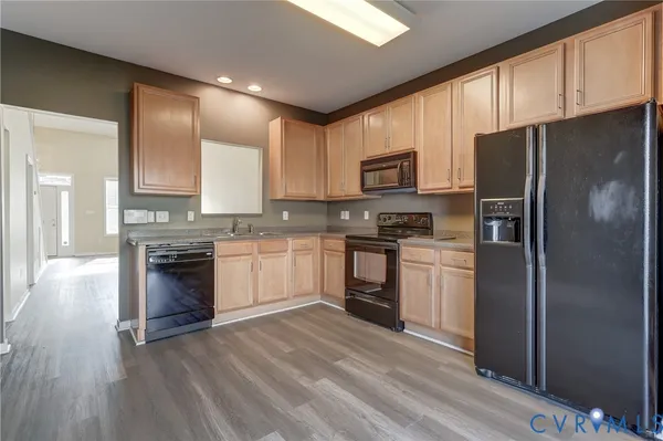 a kitchen with granite countertop white cabinets and stainless steel appliances