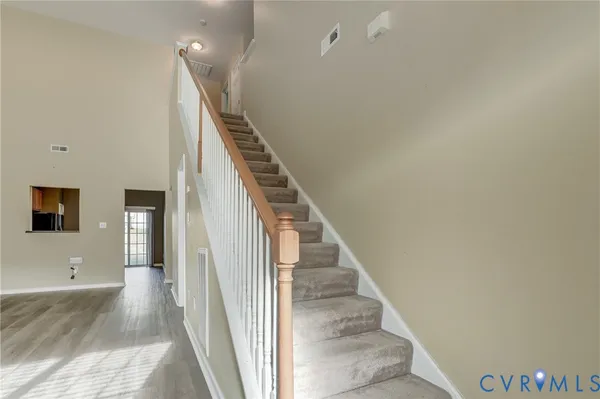 a view of a livingroom with wooden floor and stairs