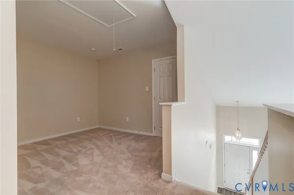 an empty room with wooden floor and bathroom