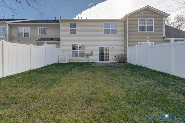 a view of a house with a yard and wooden fence