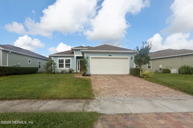 a front view of a house with a garden and yard