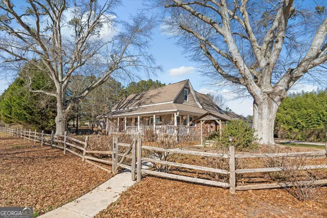 a view of a house with a small yard and a large tree