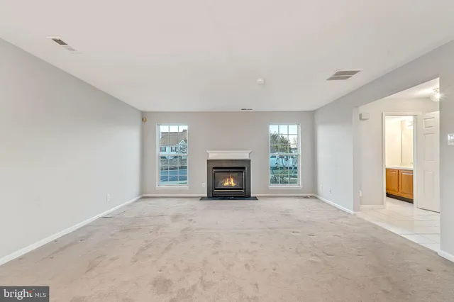 a view of an empty room with a window and a fireplace