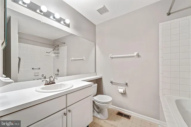 a bathroom with a sink a toilet a mirror and shower