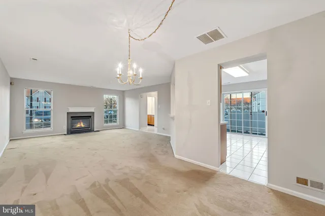 a view of an empty room with a window and fireplace