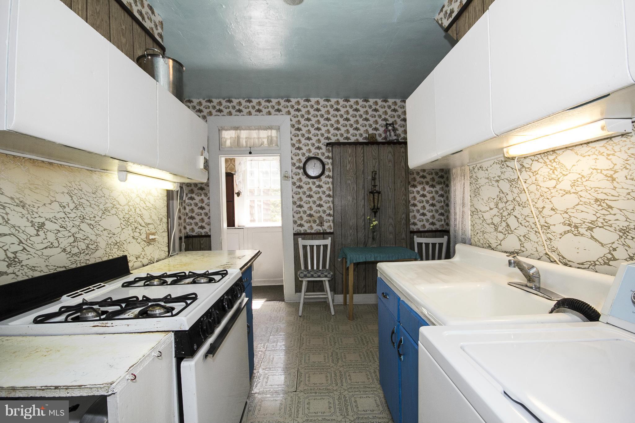 1554 South Rolling Road Baltimore, MD 21227 - Photo 12 of 22 a kitchen that has a sink a stove and a table