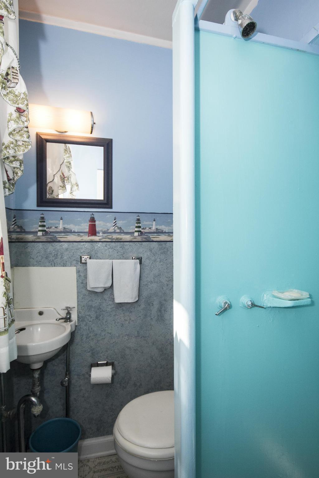 1554 South Rolling Road Baltimore, MD 21227 - Photo 13 of 22 a bathroom with a sink a toilet and mirror