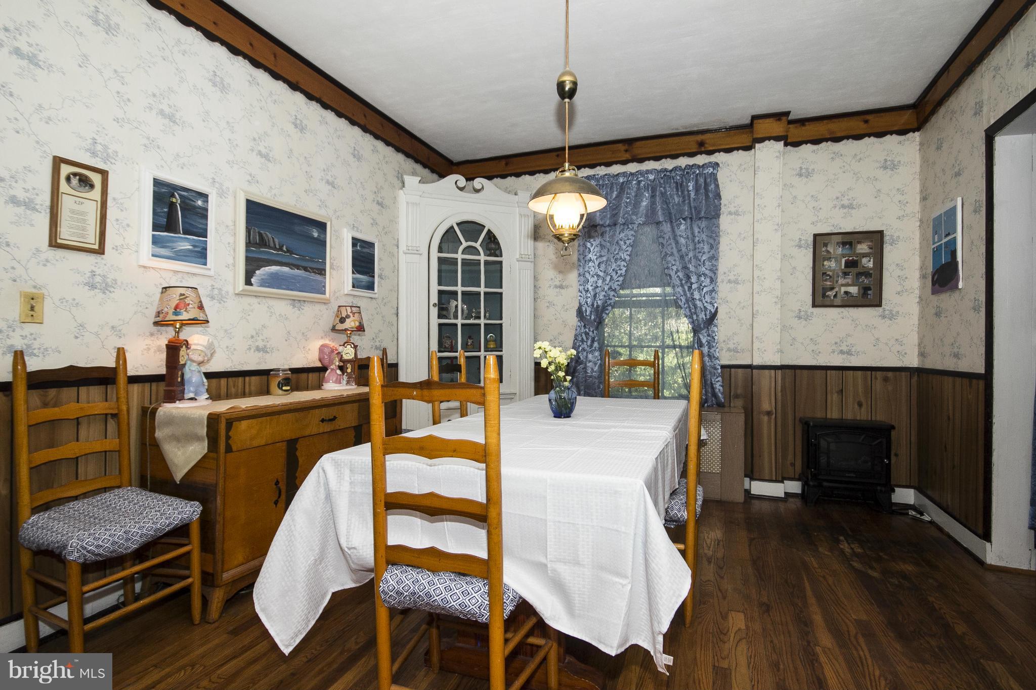 1554 South Rolling Road Baltimore, MD 21227 - Photo 6 of 22 a dining room with furniture a fireplace and wooden floor