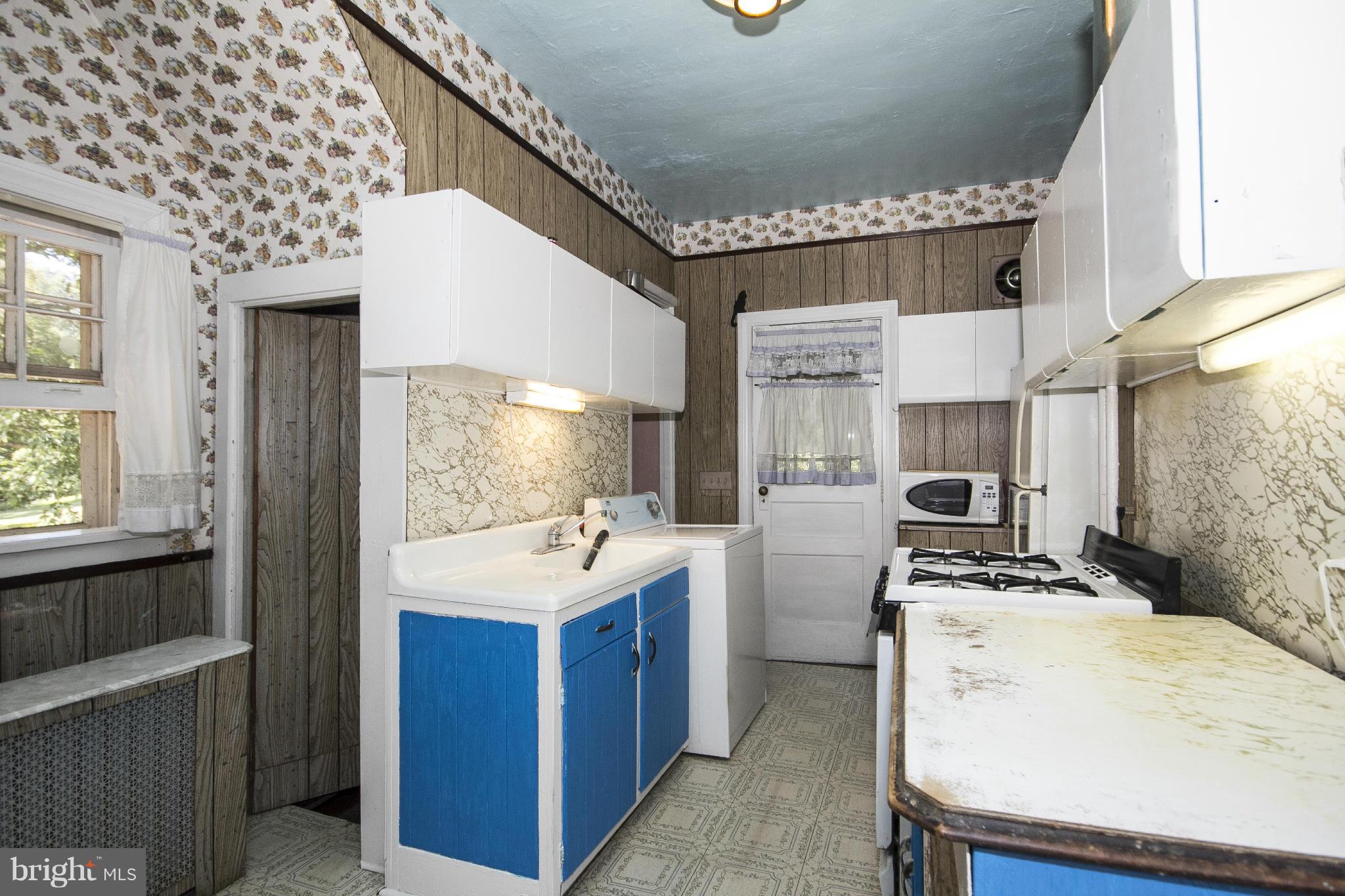 1554 South Rolling Road Baltimore, MD 21227 - Photo 10 of 22 a kitchen with a stove a sink and a refrigerator