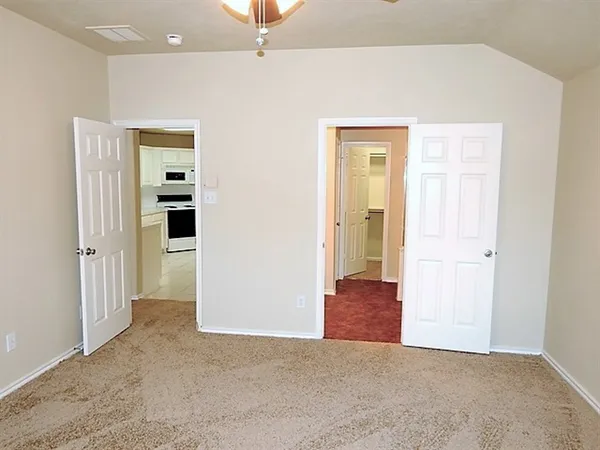 an empty room with closet and a hallway