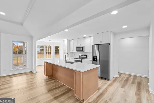 a kitchen with stainless steel appliances a refrigerator and a stove top oven