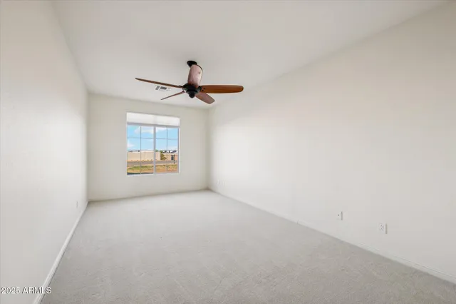 a view of wooden floor and a chandelier fan in a room