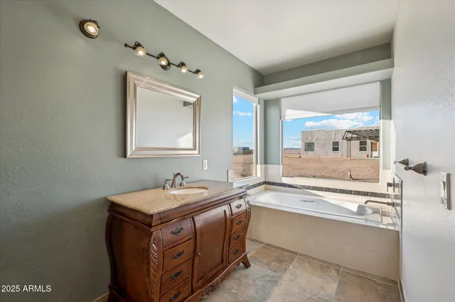 a bathroom with a tub sink and mirror