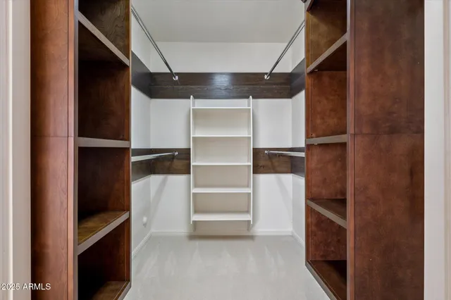 a view of walk in closet with empty racks