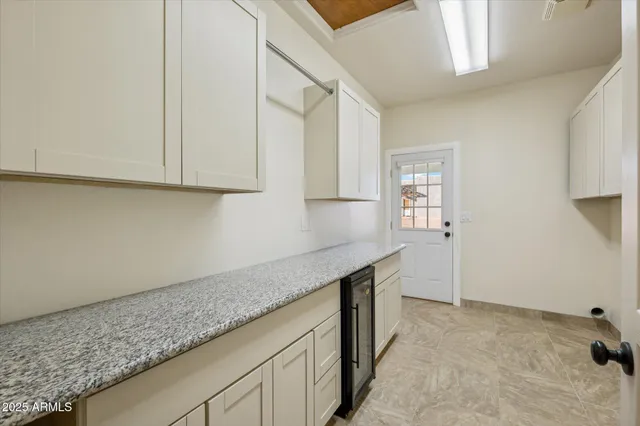 a kitchen with granite countertop a sink and white cabinets