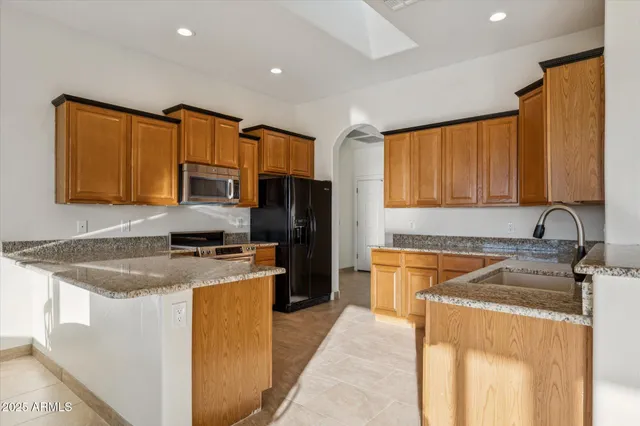 a kitchen with stainless steel appliances granite countertop a sink stove and refrigerator