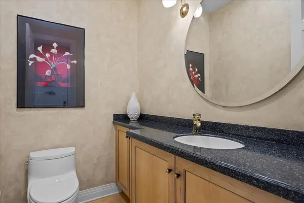 a bathroom with a toilet a sink and mirror