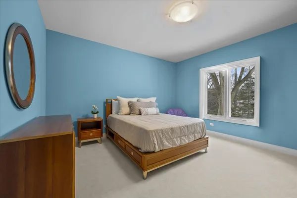 a bed sitting in a spacious bedroom next to a window