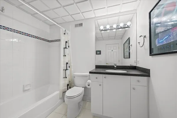 a bathroom with a granite countertop sink mirror toilet and bathtub