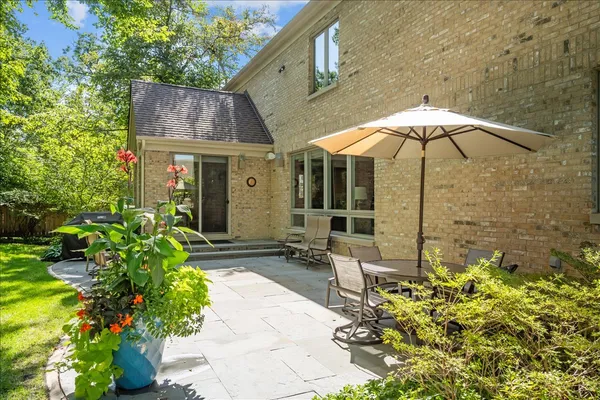 a patio with a table and chairs under an umbrella