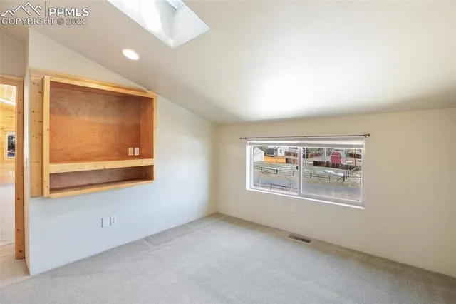 an empty room with windows and furniture