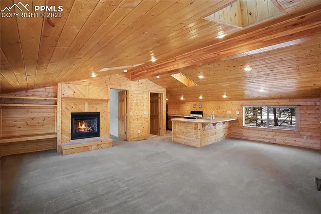 a view of an empty room with a fireplace and a window