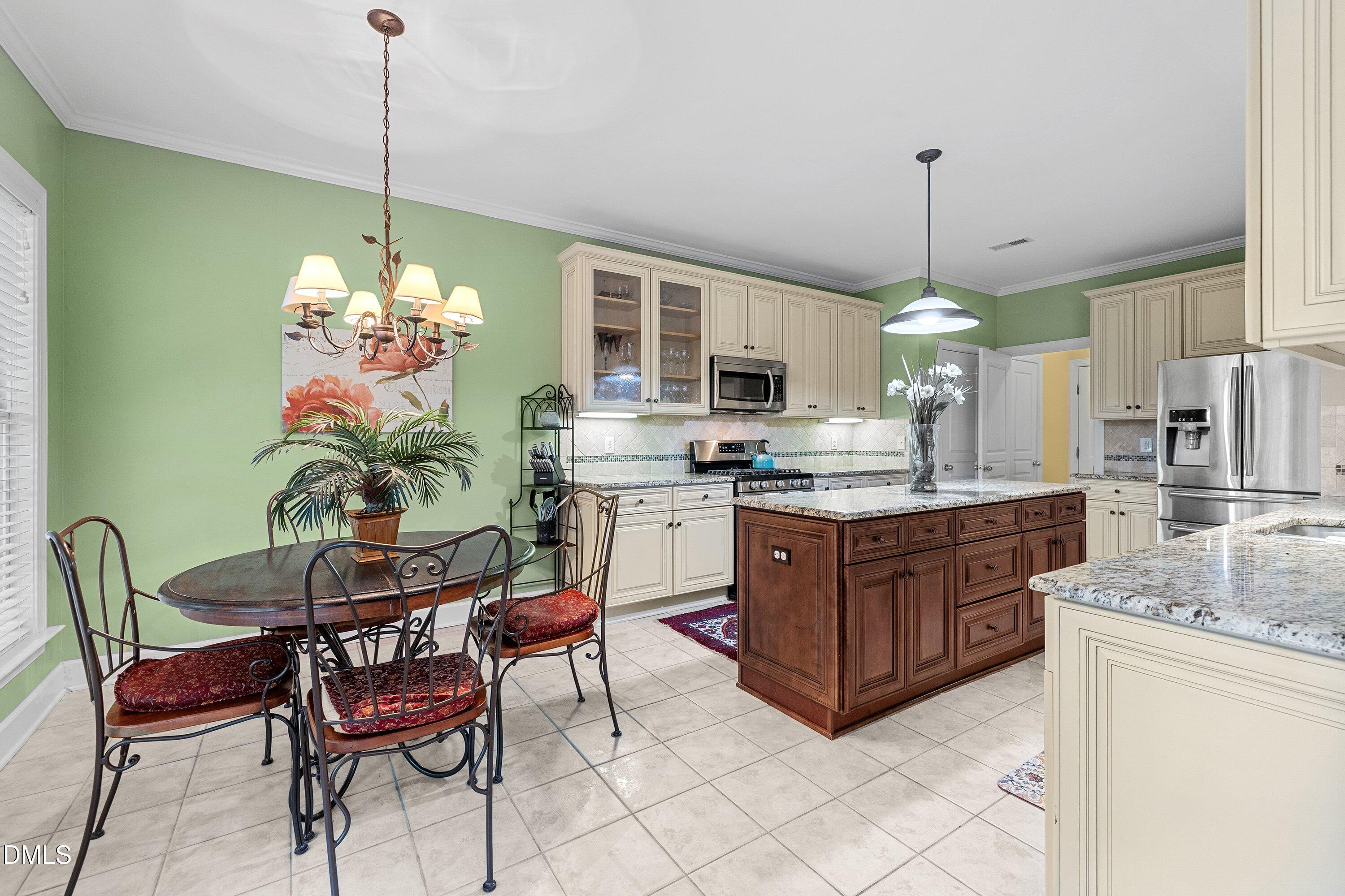3613 Lion Ridge Court Raleigh, NC 27612 - Photo 11 of 40 a kitchen with stainless steel appliances granite countertop a stove top oven a sink a dining table and chairs