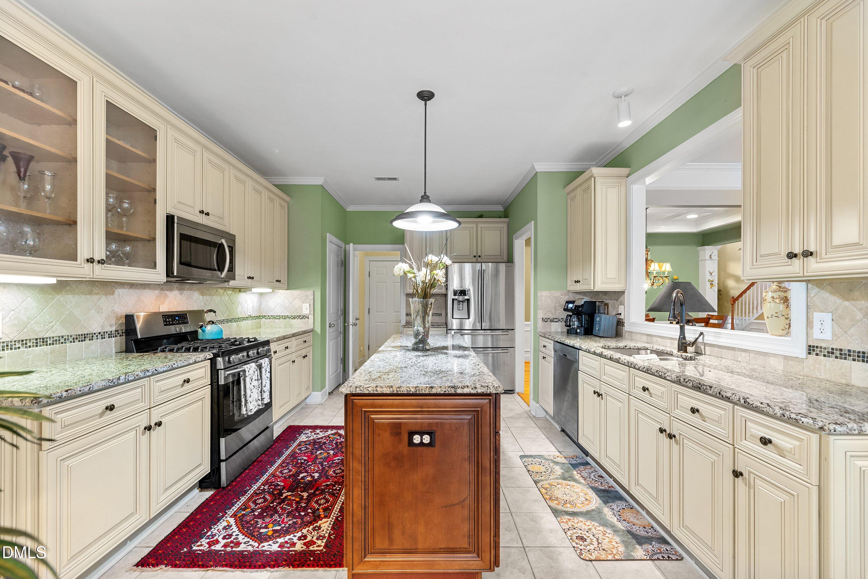 3613 Lion Ridge Court Raleigh, NC 27612 - Photo 12 of 40 a large kitchen with stainless steel appliances granite countertop a stove a sink dishwasher and a microwave oven with white cabinets