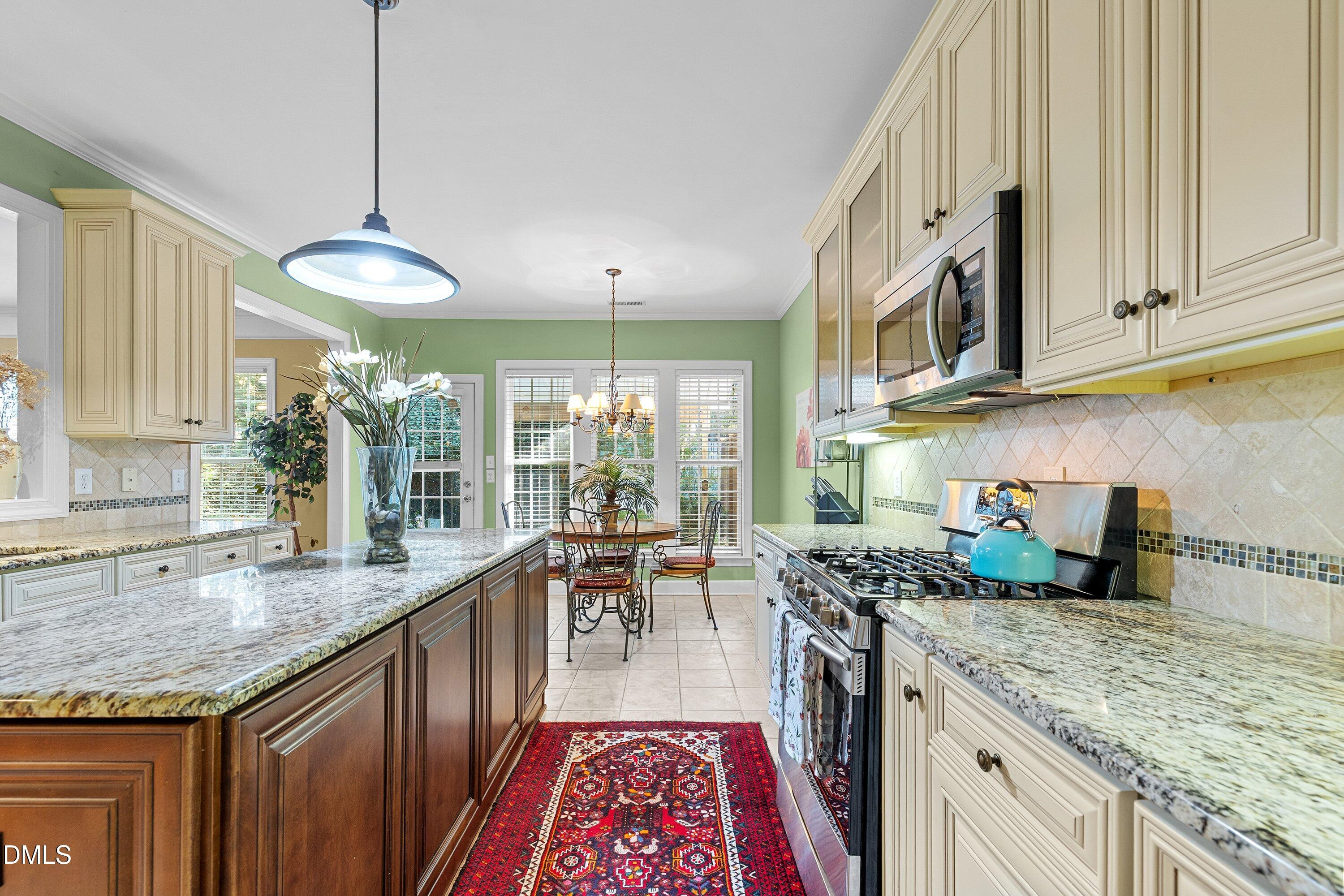 3613 Lion Ridge Court Raleigh, NC 27612 - Photo 15 of 40 a kitchen with stainless steel appliances granite countertop a stove a sink dishwasher and cabinets with wooden floor