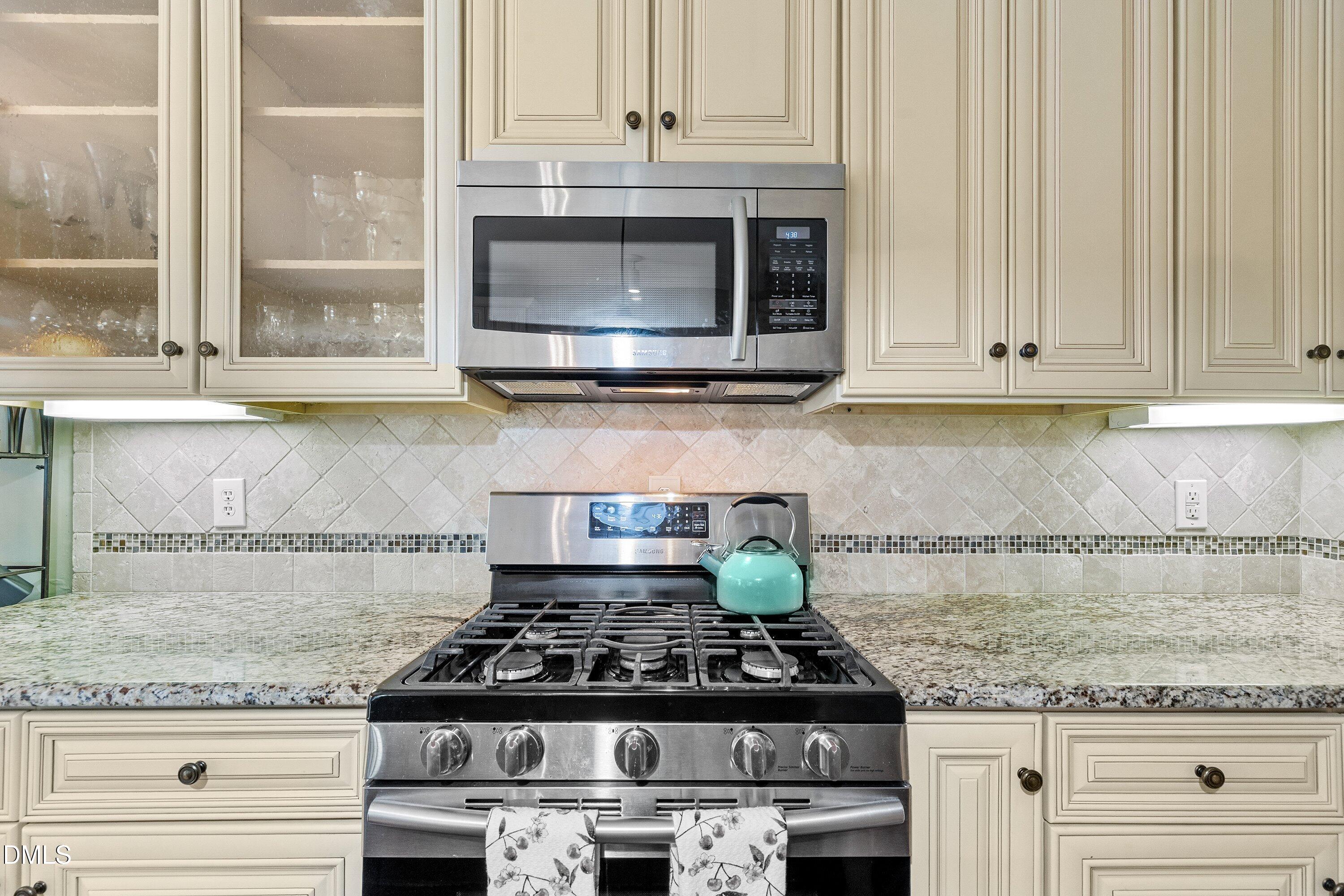 3613 Lion Ridge Court Raleigh, NC 27612 - Photo 16 of 40 a kitchen with granite countertop a stove and a sink