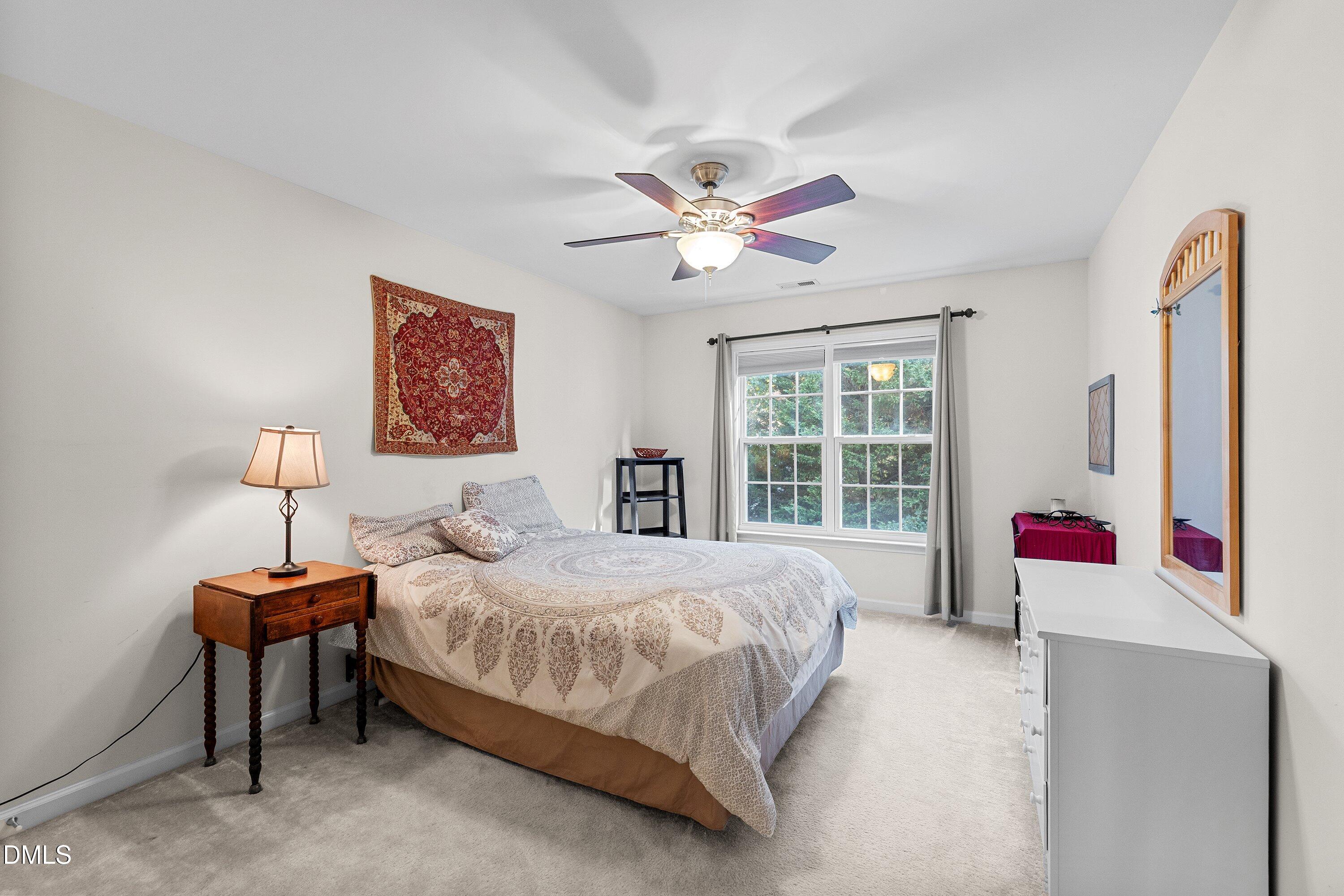 3613 Lion Ridge Court Raleigh, NC 27612 - Photo 21 of 40 a bedroom with a bed and a chandelier