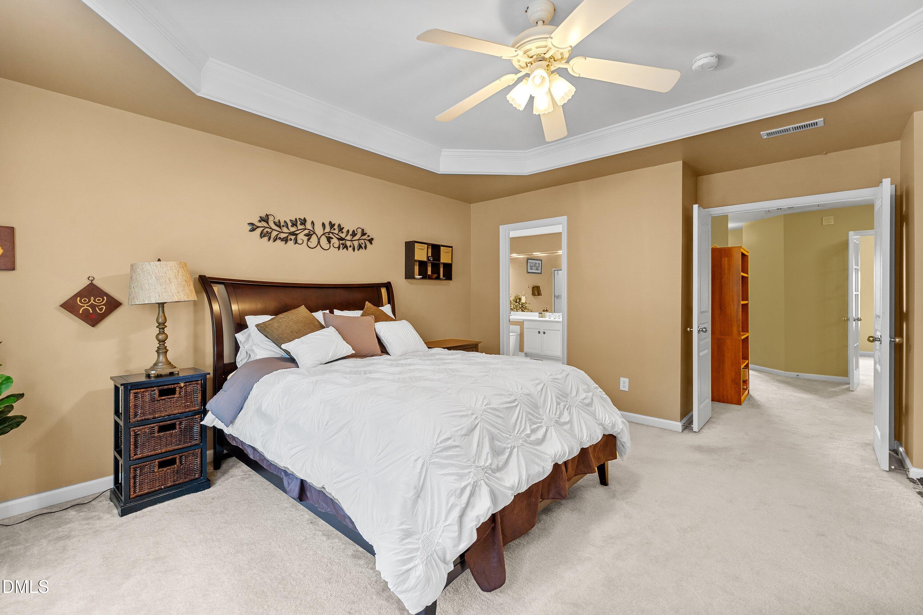 3613 Lion Ridge Court Raleigh, NC 27612 - Photo 26 of 40 a bedroom with a bed and a chandelier