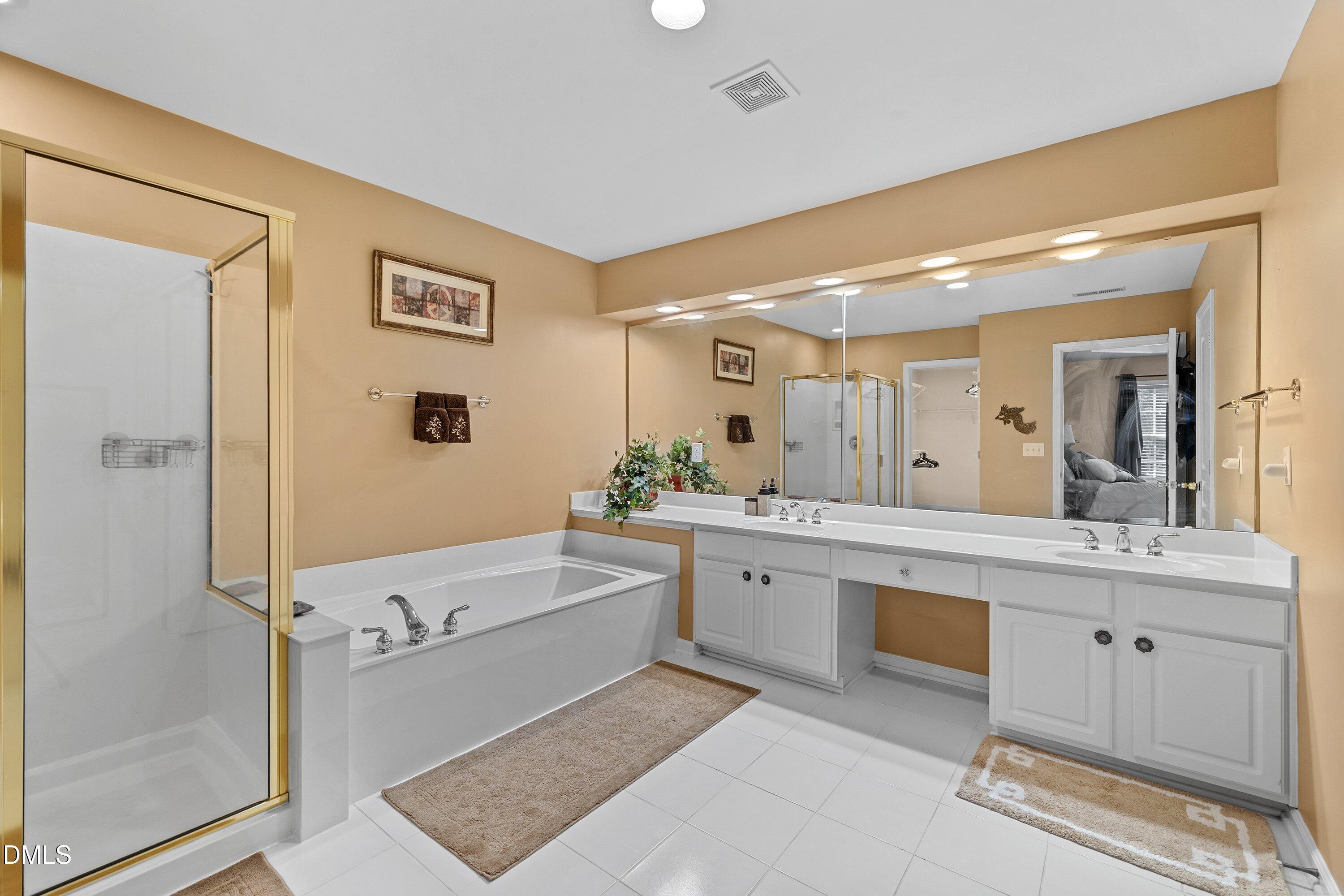 3613 Lion Ridge Court Raleigh, NC 27612 - Photo 28 of 40 a spacious bathroom with a tub sink and mirror