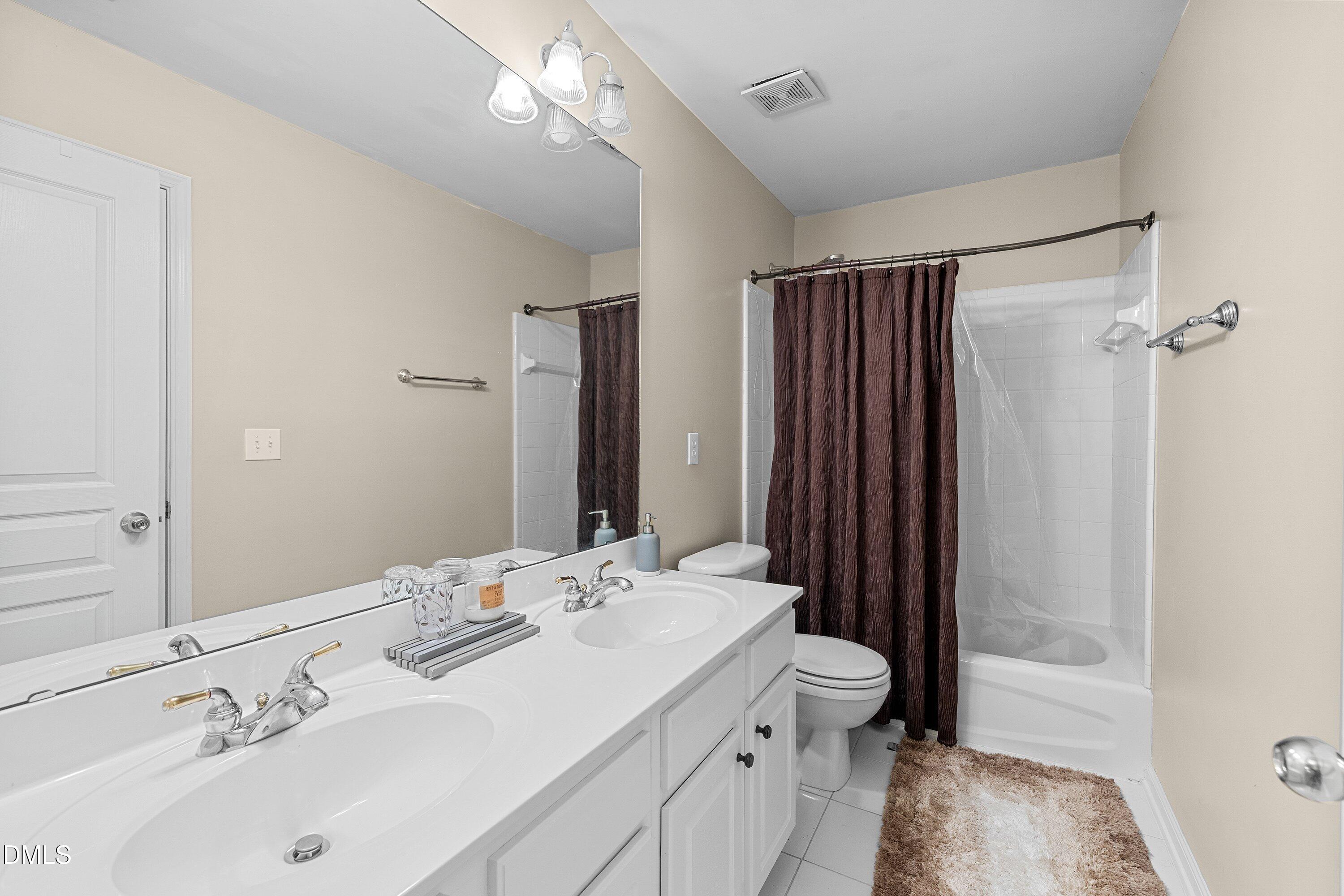 3613 Lion Ridge Court Raleigh, NC 27612 - Photo 31 of 40 a bathroom with a double vanity sink mirror and toilet