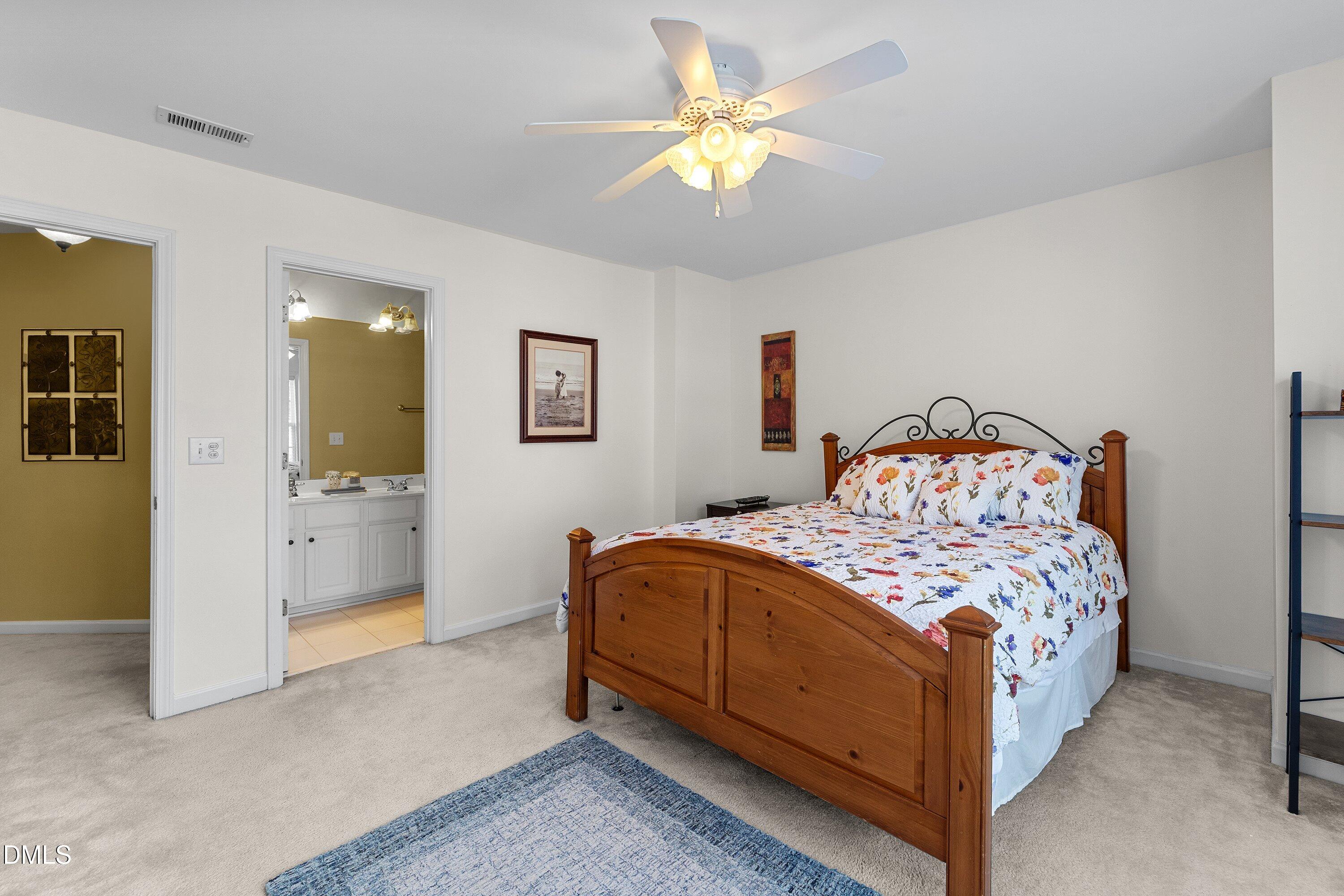 3613 Lion Ridge Court Raleigh, NC 27612 - Photo 33 of 40 a bedroom with a bed a chandelier and a dresser