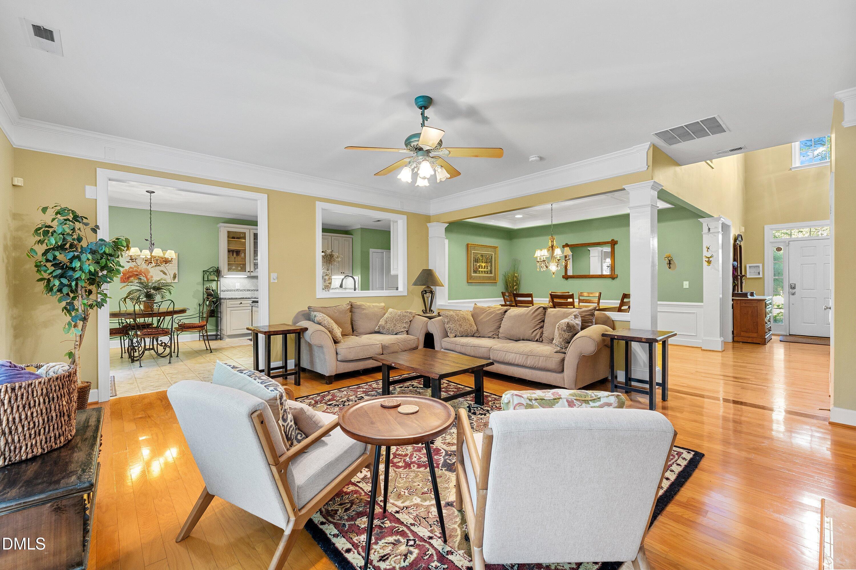 3613 Lion Ridge Court Raleigh, NC 27612 - Photo 8 of 40 a living room with couches a coffee table and a chandelier with wooden floor
