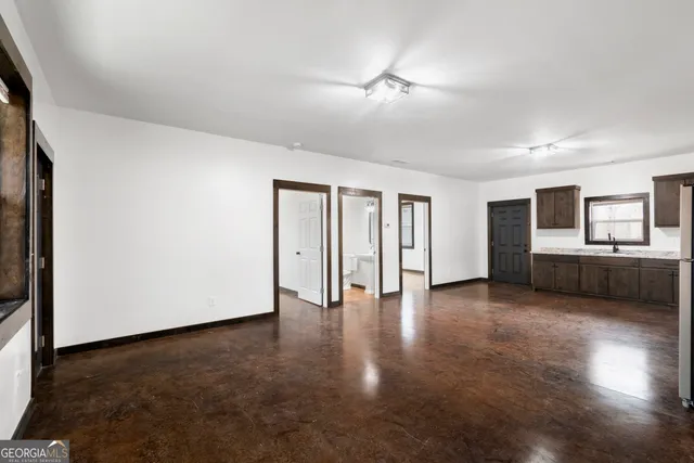 a large kitchen with a stove a sink dishwasher a refrigerator and a oven with wooden floor