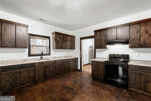 a kitchen with stainless steel appliances granite countertop a stove a sink and a microwave