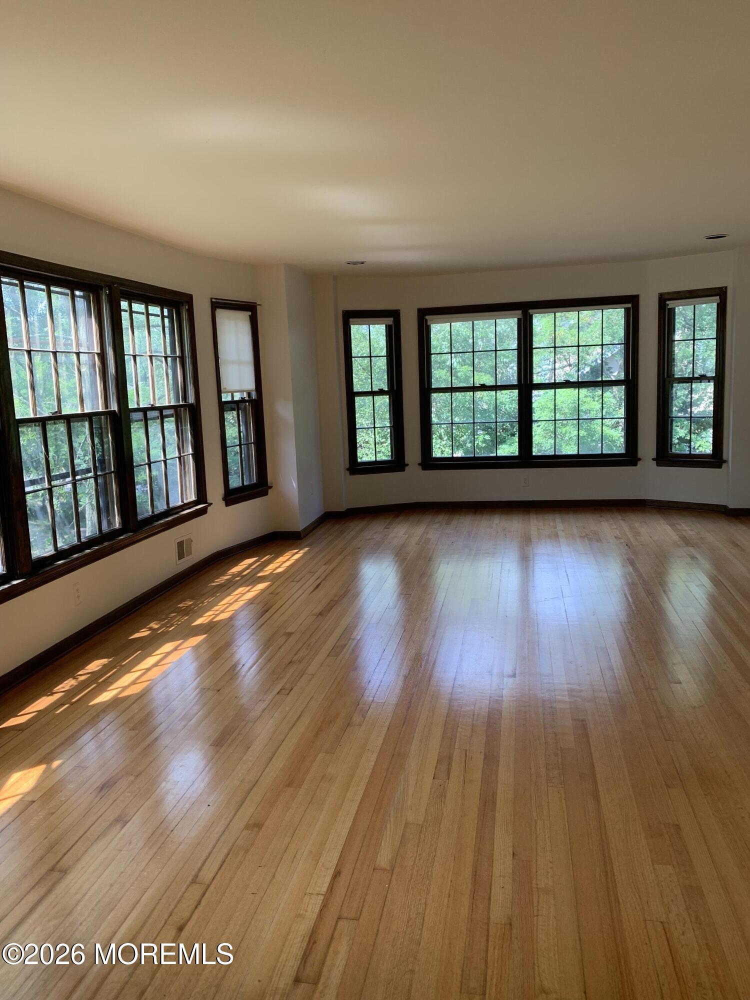 2 Carbury Road Asbury Park, NJ 07712 - Photo 4 of 21 wooden floor in an empty room with a window