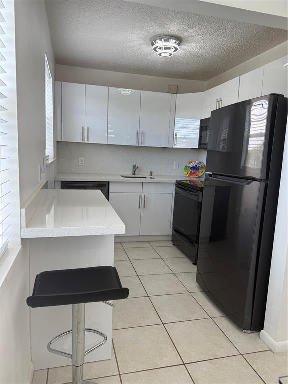 144 Farnham F Deerfield Beach, FL 33442 - Photo 20 of 36 a kitchen with stainless steel appliances a refrigerator sink and cabinets
