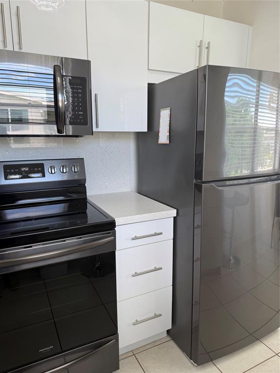 144 Farnham F Deerfield Beach, FL 33442 - Photo 25 of 36 a kitchen with stainless steel appliances a refrigerator and cabinets