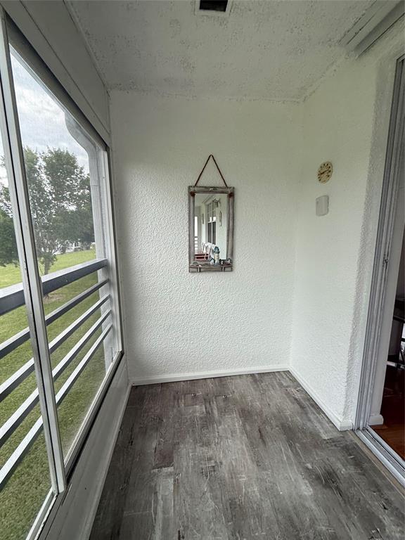 144 Farnham F Deerfield Beach, FL 33442 - Photo 31 of 36 an empty room with wooden floor and windows