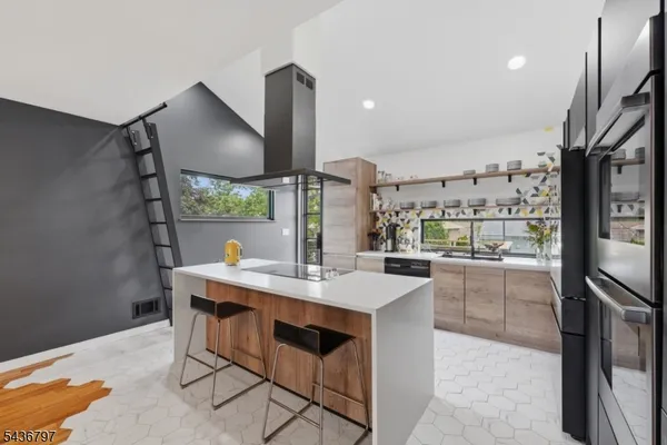 a kitchen with stainless steel appliances kitchen island granite countertop a sink and a stove