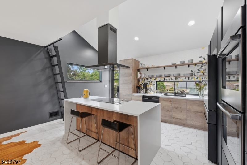 a kitchen with stainless steel appliances kitchen island granite countertop a sink and a stove